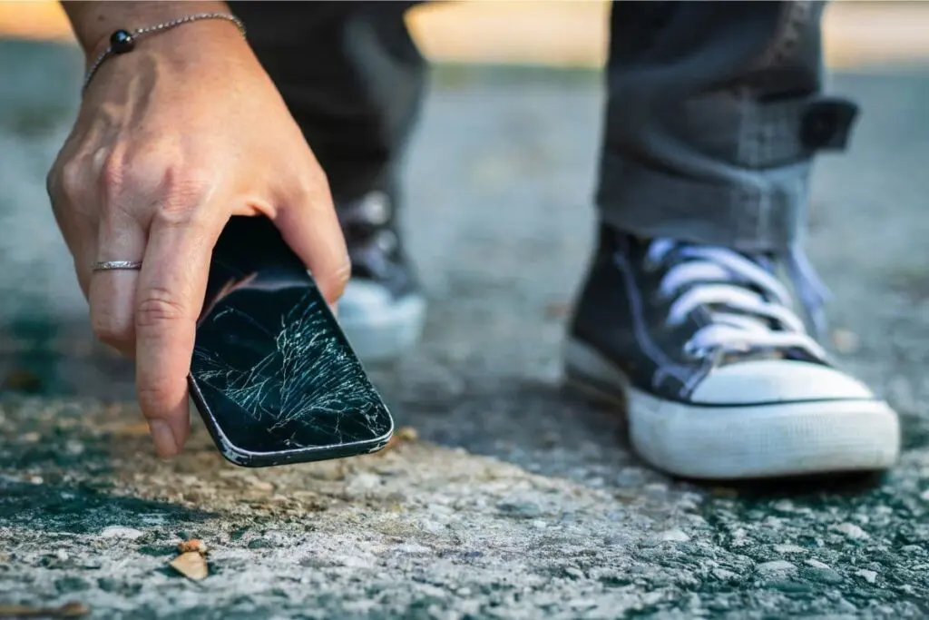 Ile kosztuje wymiana szyby w telefonie - smartfon upada na asfalt