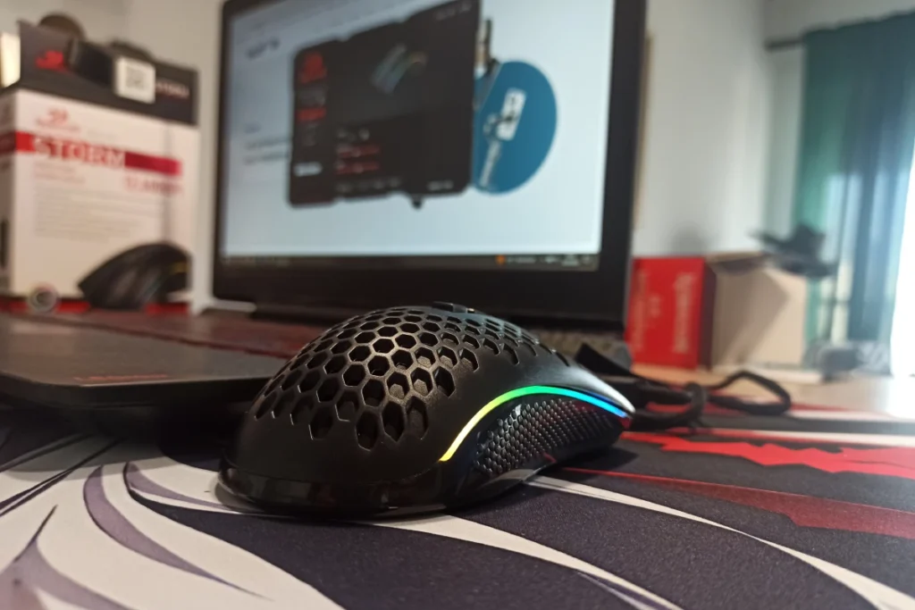 Myszka gamingowa Redragon M808-RGB Storm przy laptopie na biurku