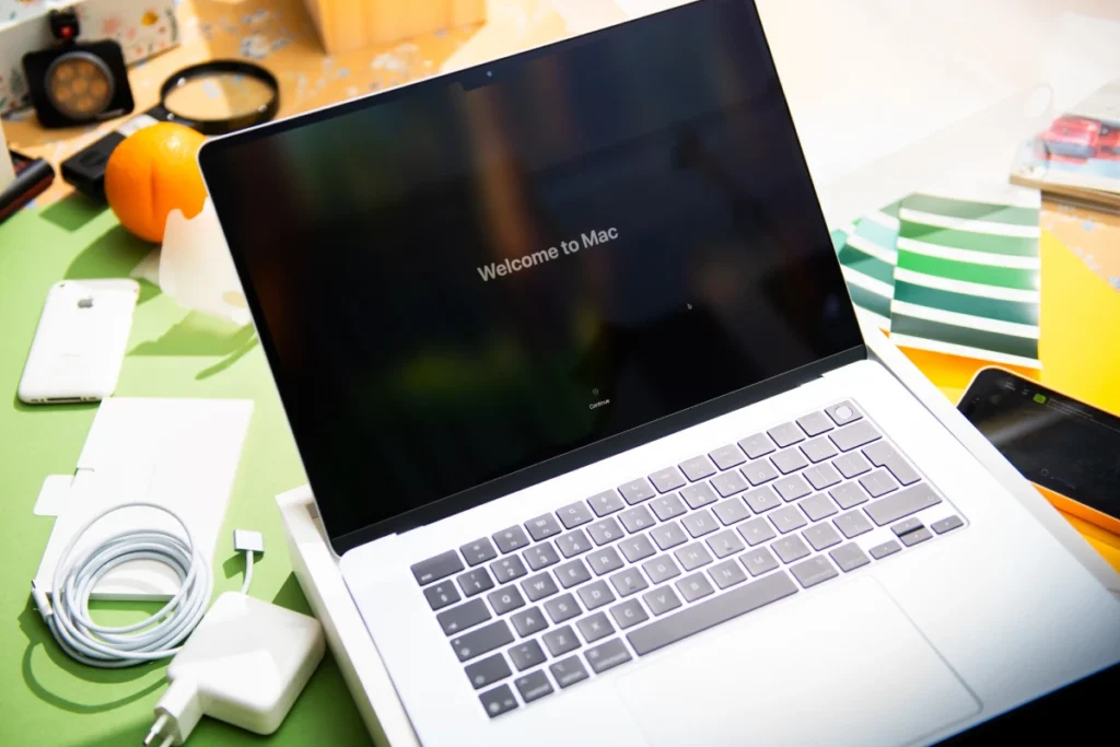 macbook na tle różnych akcesoriów