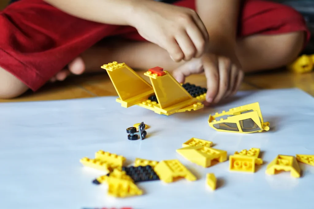 dziecko bawiące się żółtymi klockami lego